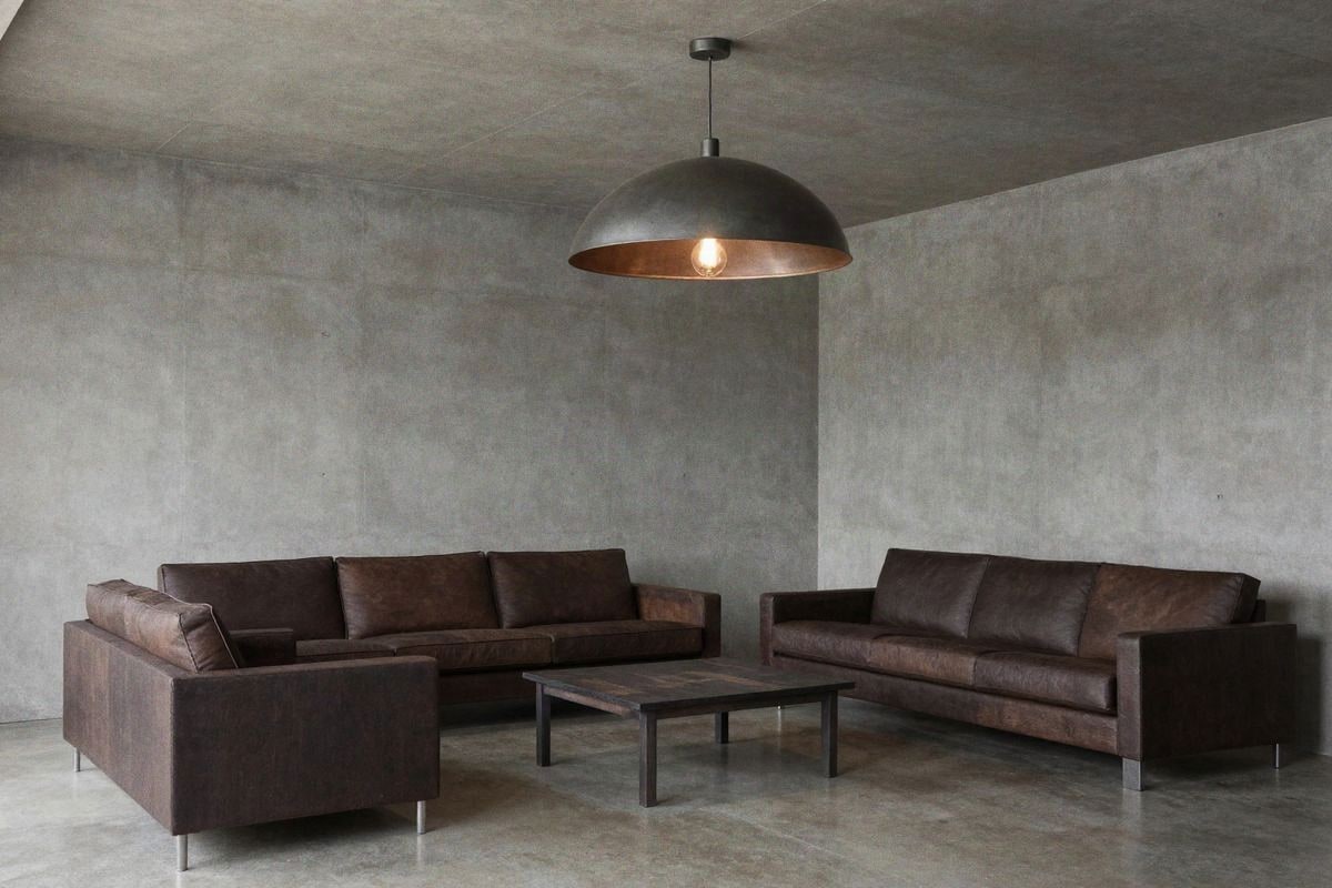 Imagen ilustrativa: salón industrial con techo bajo y colgante de metal mate.